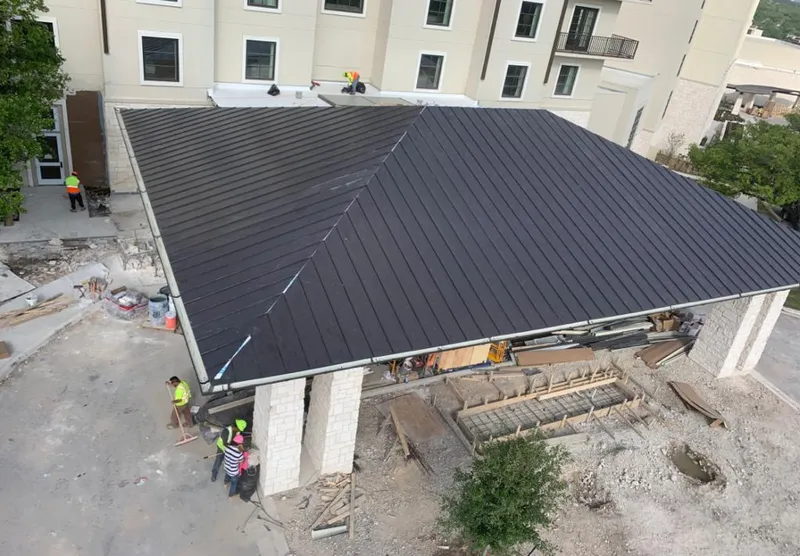Metal roofing installation team working on a commercial building in University City